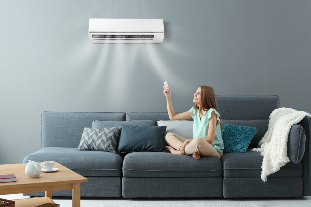 Happy woman sitting under ductless AC